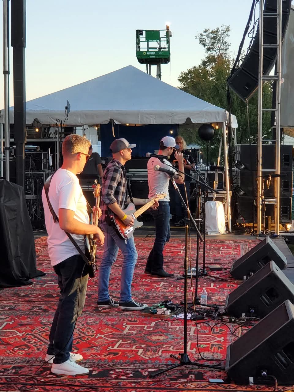 Greg Warren Band members on stage at an outdoor festival soundcheck