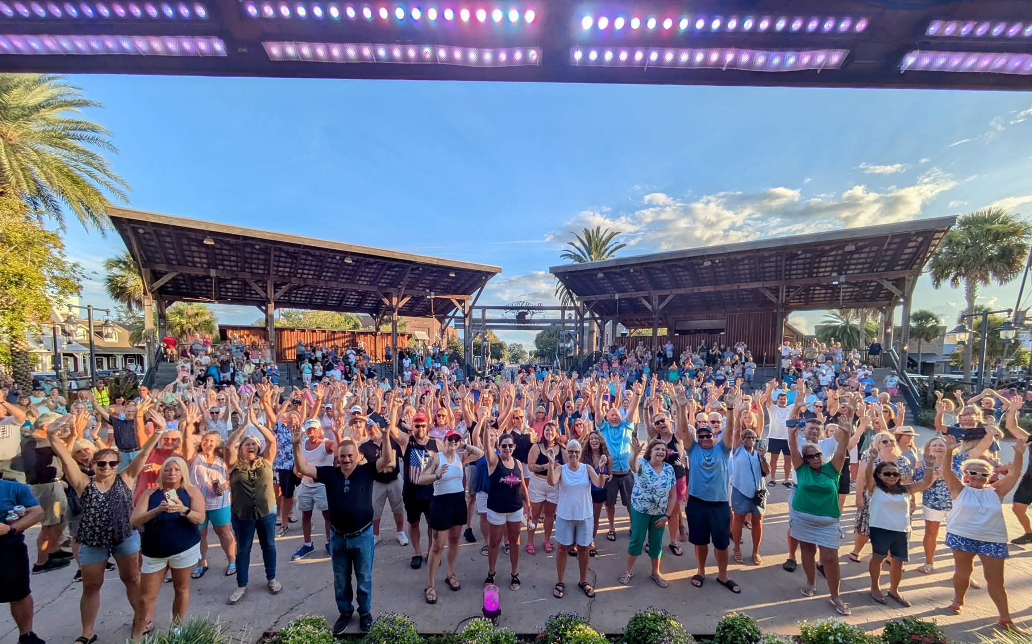 Massive crowd with hands raised at a Greg Warren Band outdoor concert in Florida